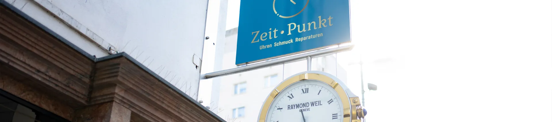 Firmenschild und Uhr des Juweliers Zeit-Punkt an der Außenfassade in Wr. Neustadt