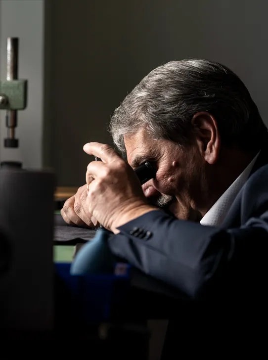 Uhrmacher arbeitet konzentriert mit Lupe in der Meisterwerkstatt von Zeit-Punkt in Wr. Neustadt