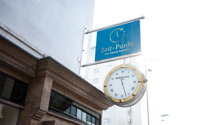 Firmenschild und Uhr des Juweliers Zeit-Punkt an der Außenfassade in Wr. Neustadt